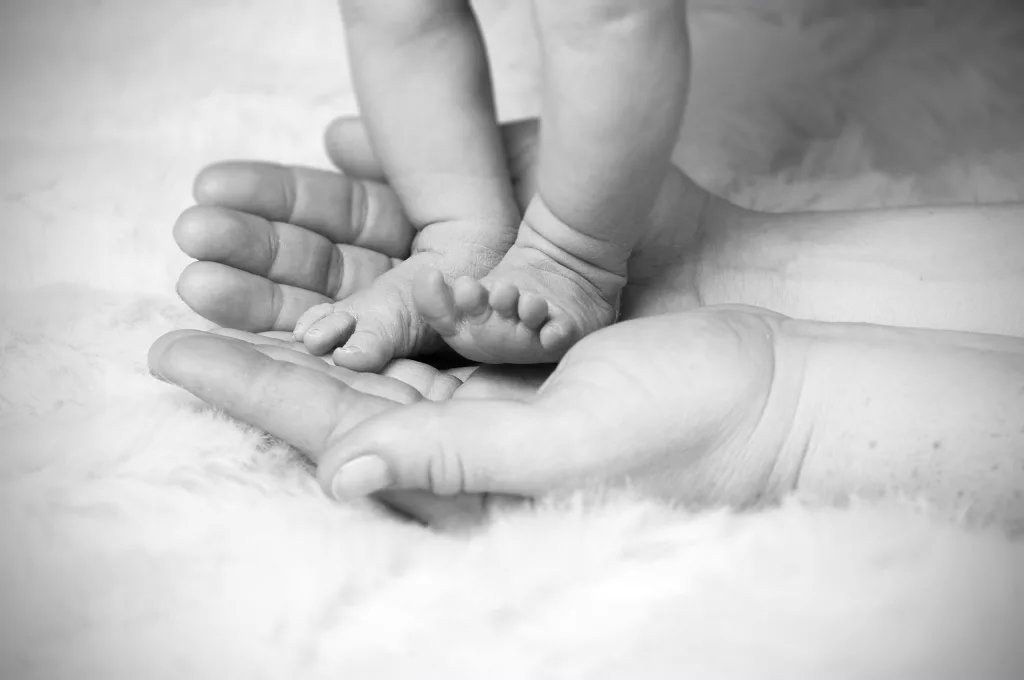 Baby feet on top of mother's hands